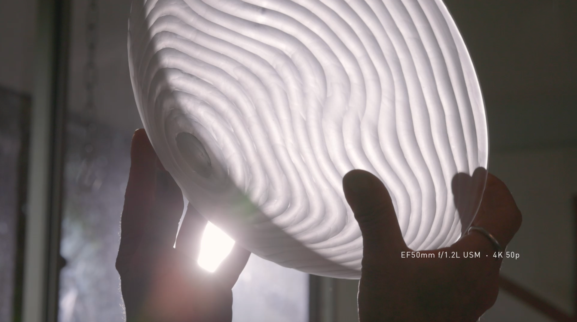 Barbara holding a glass against the light in her studio